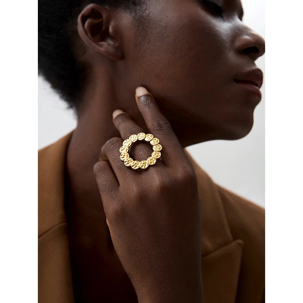 Anillo dorado circular con textura martillada · Sole